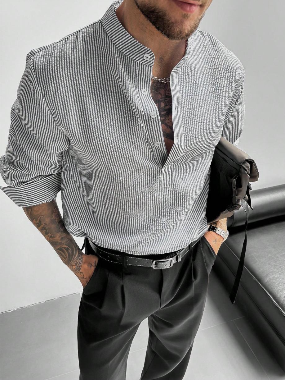 Chemise à rayures grises à col mao, portée dans un pantalon à pinces avec ceinture noire