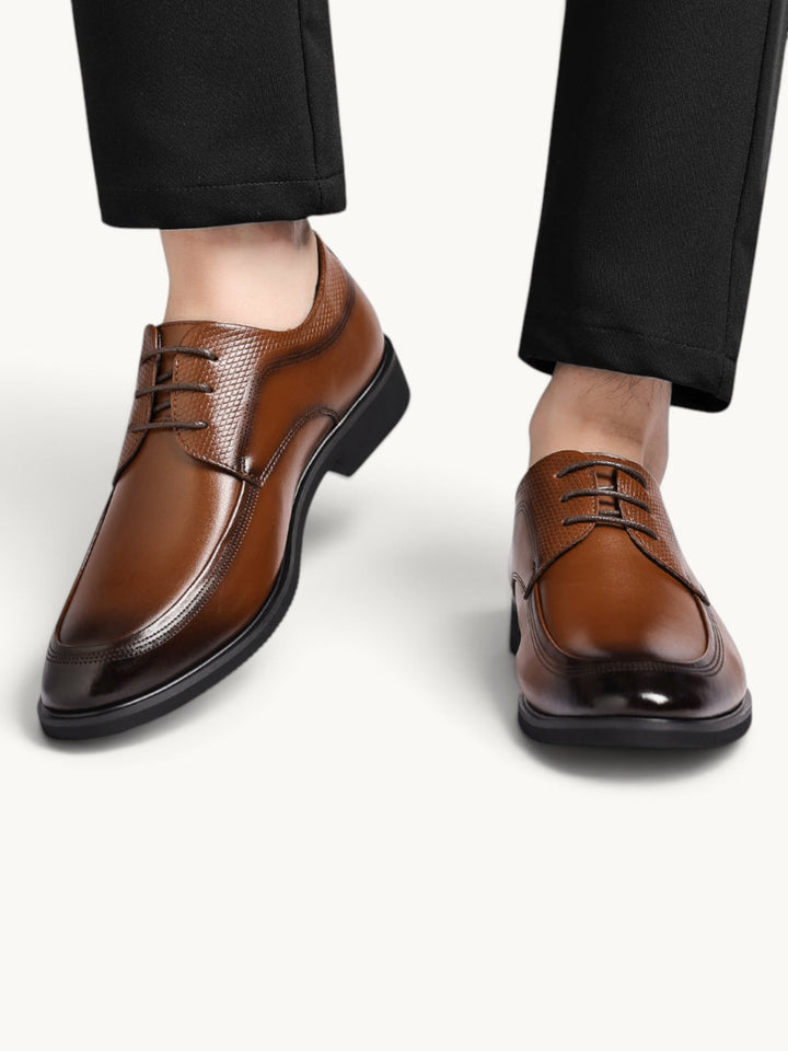 Chaussures derbies en cuir lisse marron à lacets, portées avec un pantalon noir