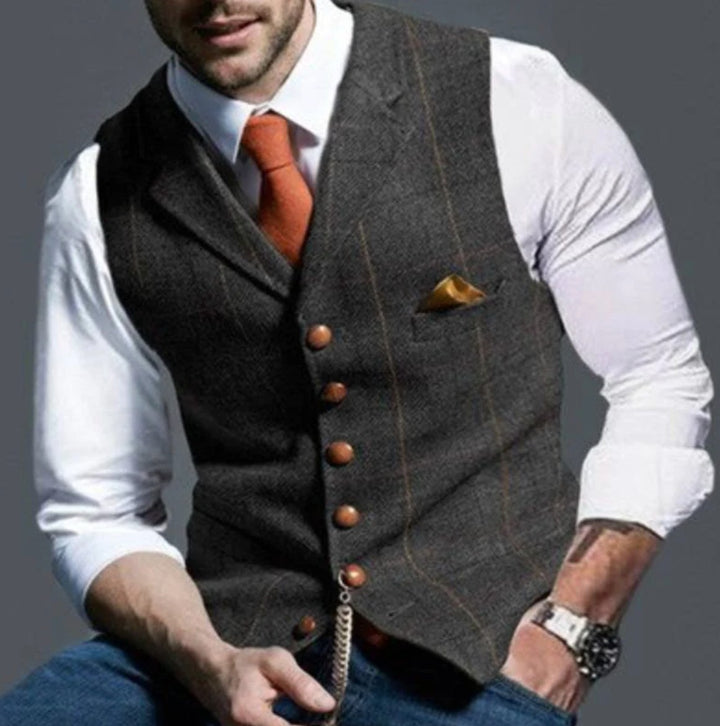 Gilet gris foncé à carreaux fenêtre discrets, cravate orange et chaîne dorée