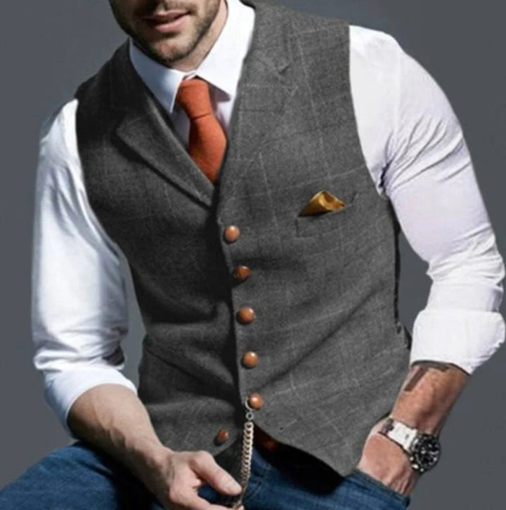 Gilet gris à carreaux fenêtre, cravate orange et chaîne de montre dorée