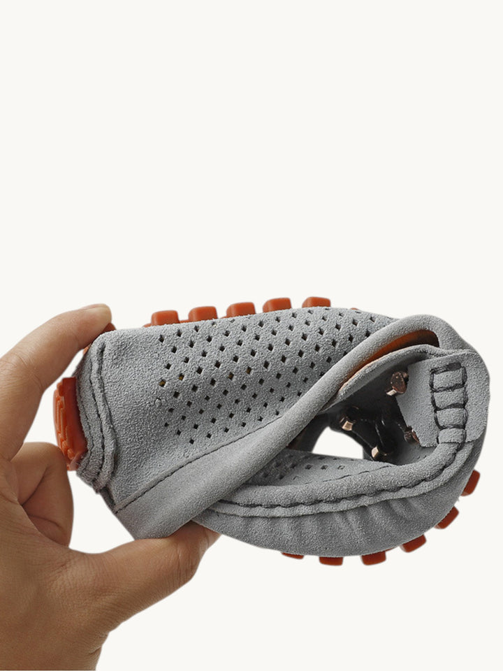 Mocassin gris perforé plié à la main pour montrer sa souplesse