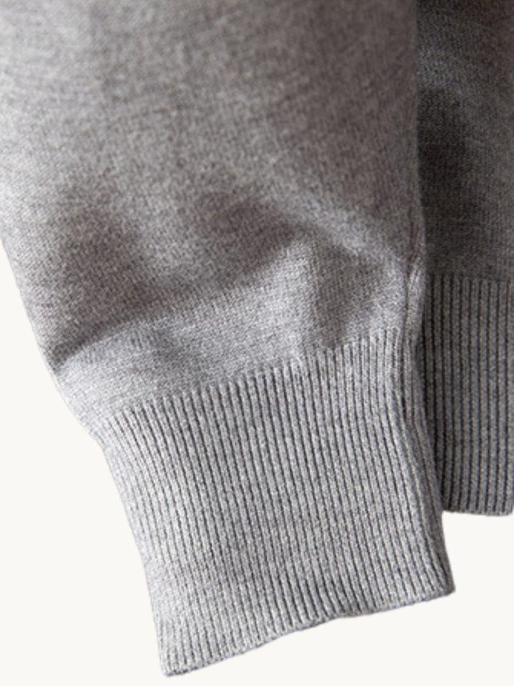 Pull en maille grise col V, détail des manches côtelées et finitions