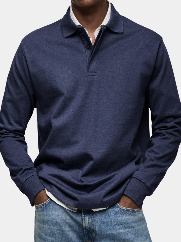 Polo à manches longues bleu ardoise chiné porté sur une chemise blanche et un jean