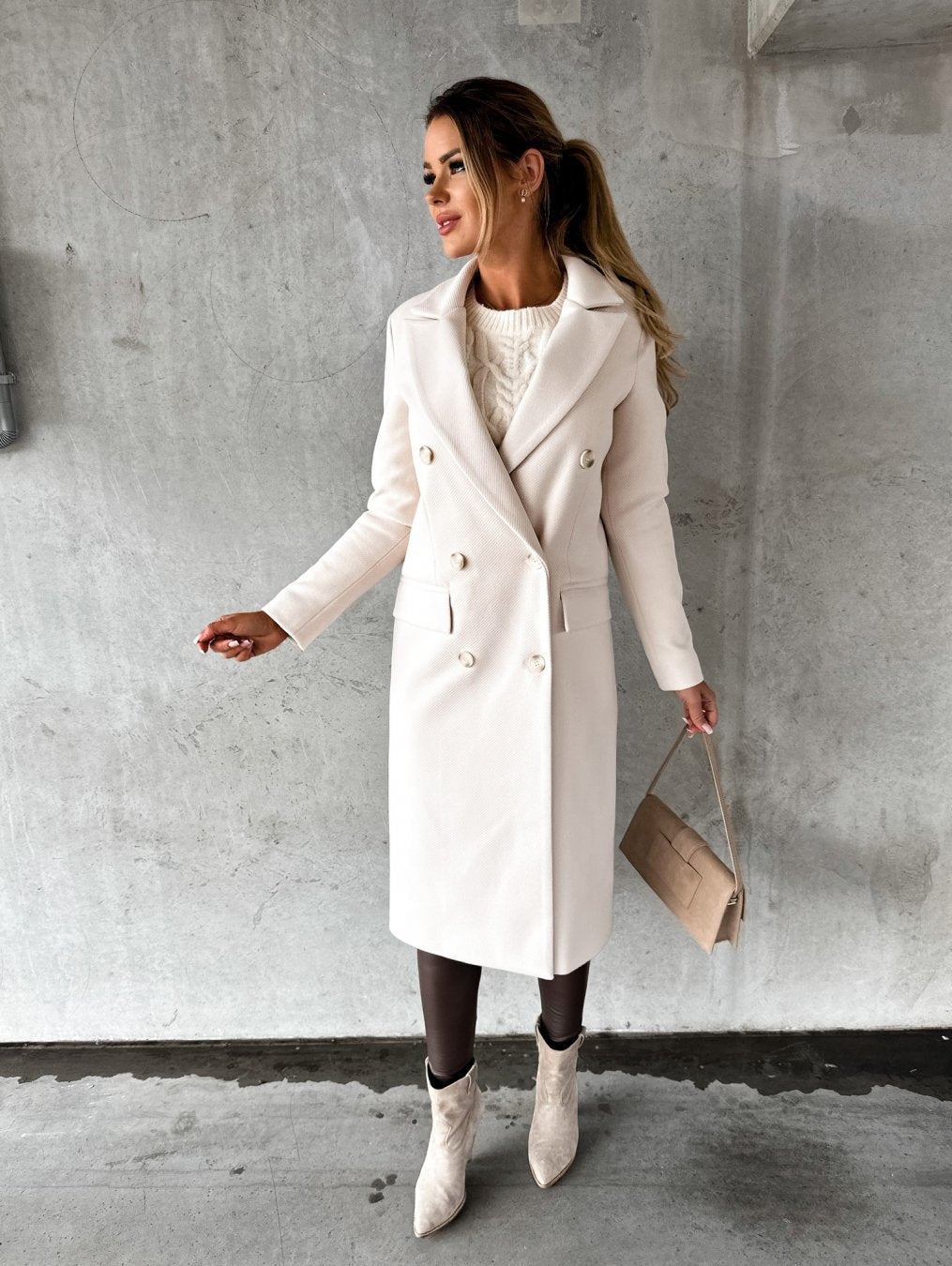 Manteau long croisé cintré, coloris ivoire, porté en tenue