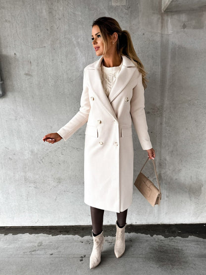 Manteau long croisé cintré, coloris ivoire, porté en tenue