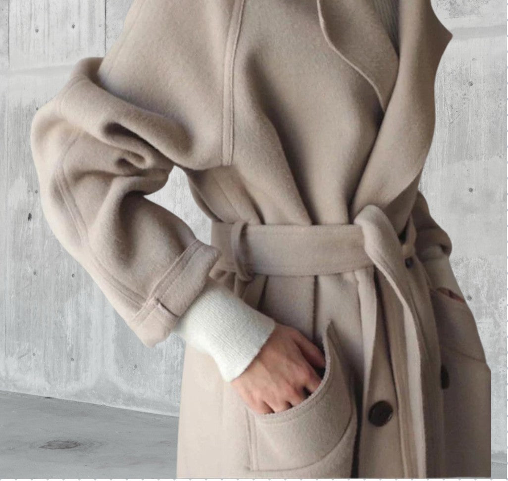 Détail du manteau en laine beige, ceinture nouée à la taille et poignet