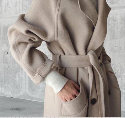 Détail du manteau en laine beige, ceinture nouée à la taille et poignet