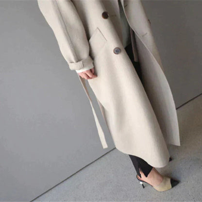 Manteau long en laine beige, vue en plongée sur le bas et la ceinture