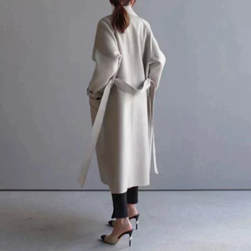 Manteau long en laine beige vu de dos, ceinture nouée à la taille
