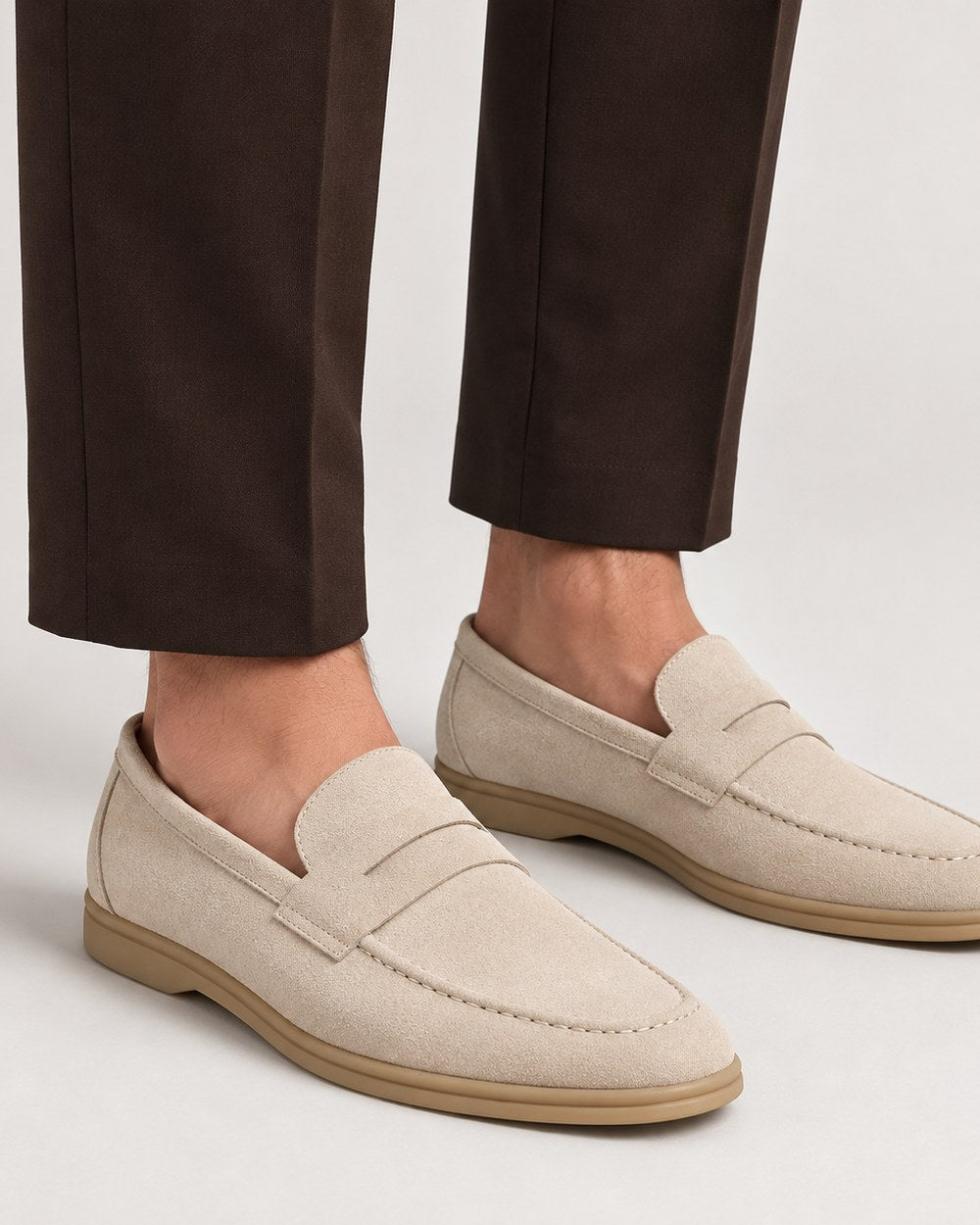 Mocassins en daim crème à semelle beige, portés avec un pantalon brun