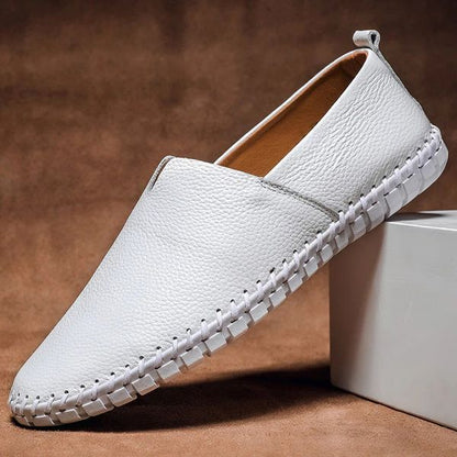 Mocassin homme blanc vu de profil, tirette au talon et couture apparente
