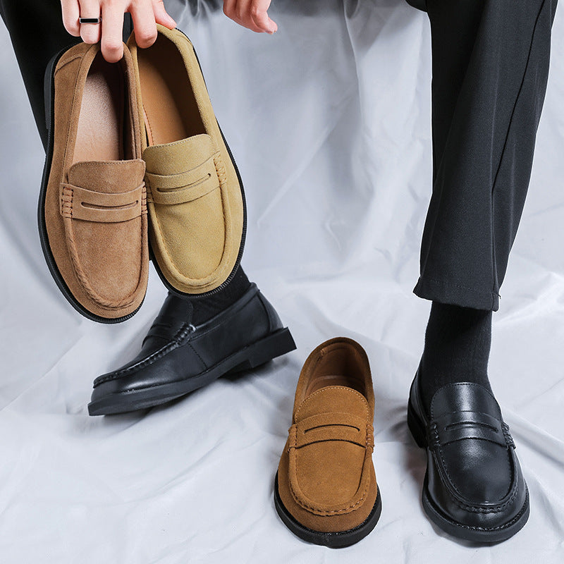 Mocassins en daim camel sans lacets tenus a la main, portes avec un pantalon noir