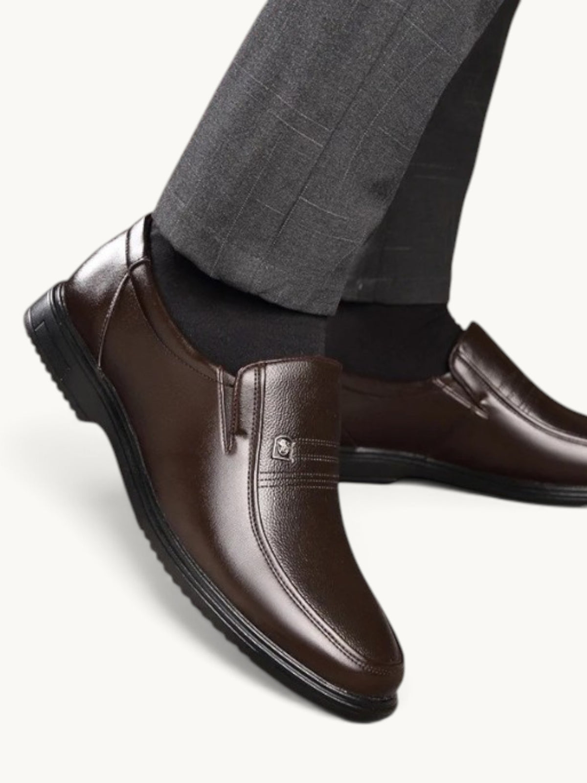 Mocassin en cuir marron semi-brillant, porté avec costume gris et chaussettes noires