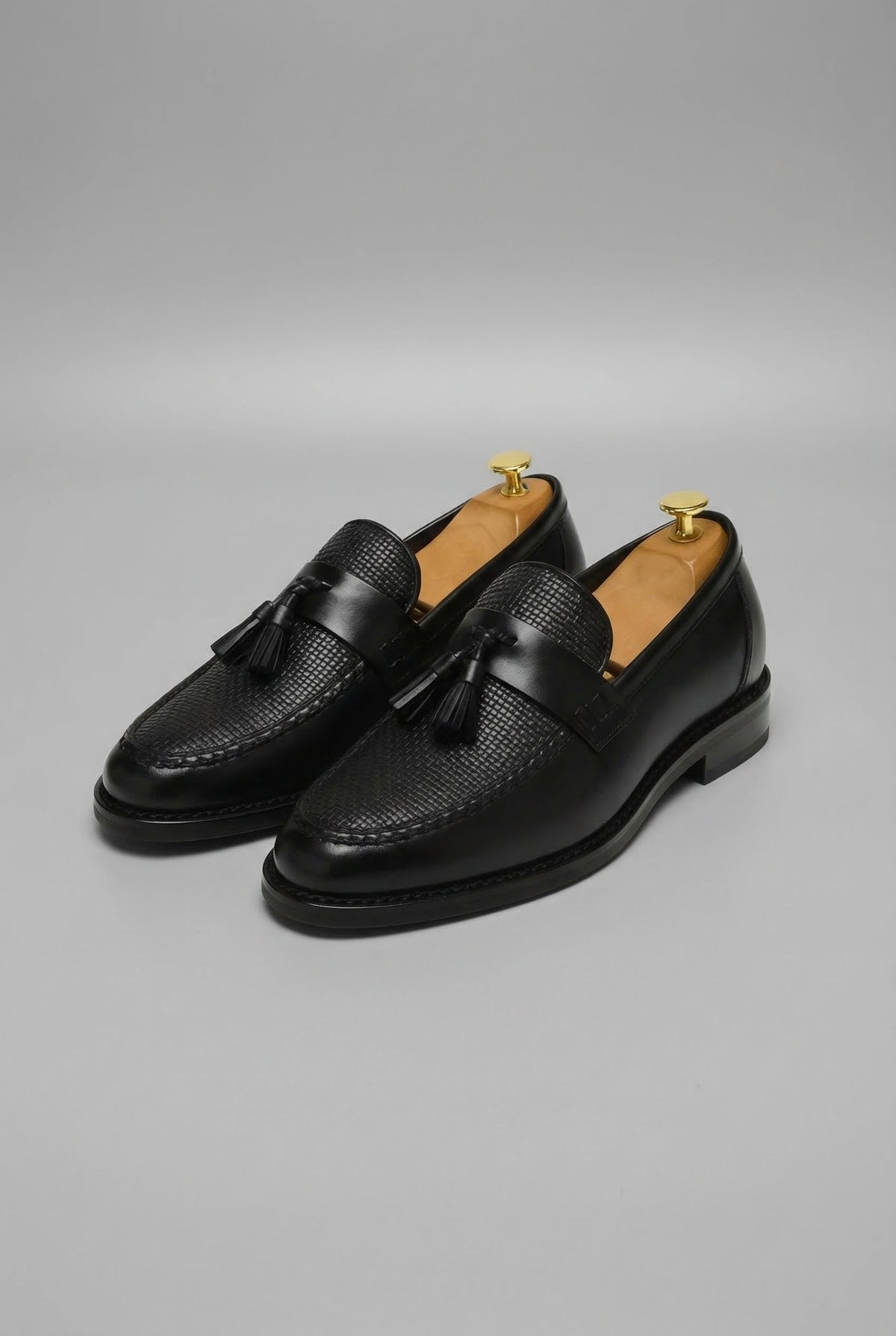 Paire de mocassins à pampilles noirs, empeigne tressée, vue de trois quarts