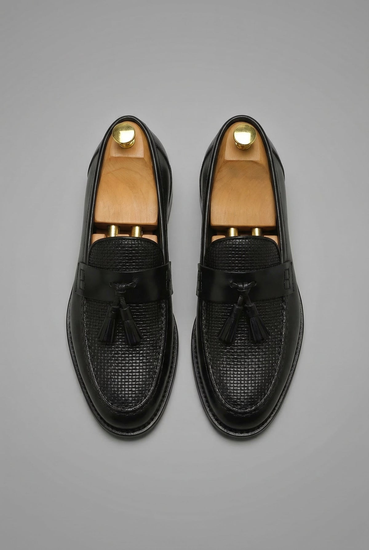 Mocassins à pampilles noirs vus du dessus, empeigne au motif tressé