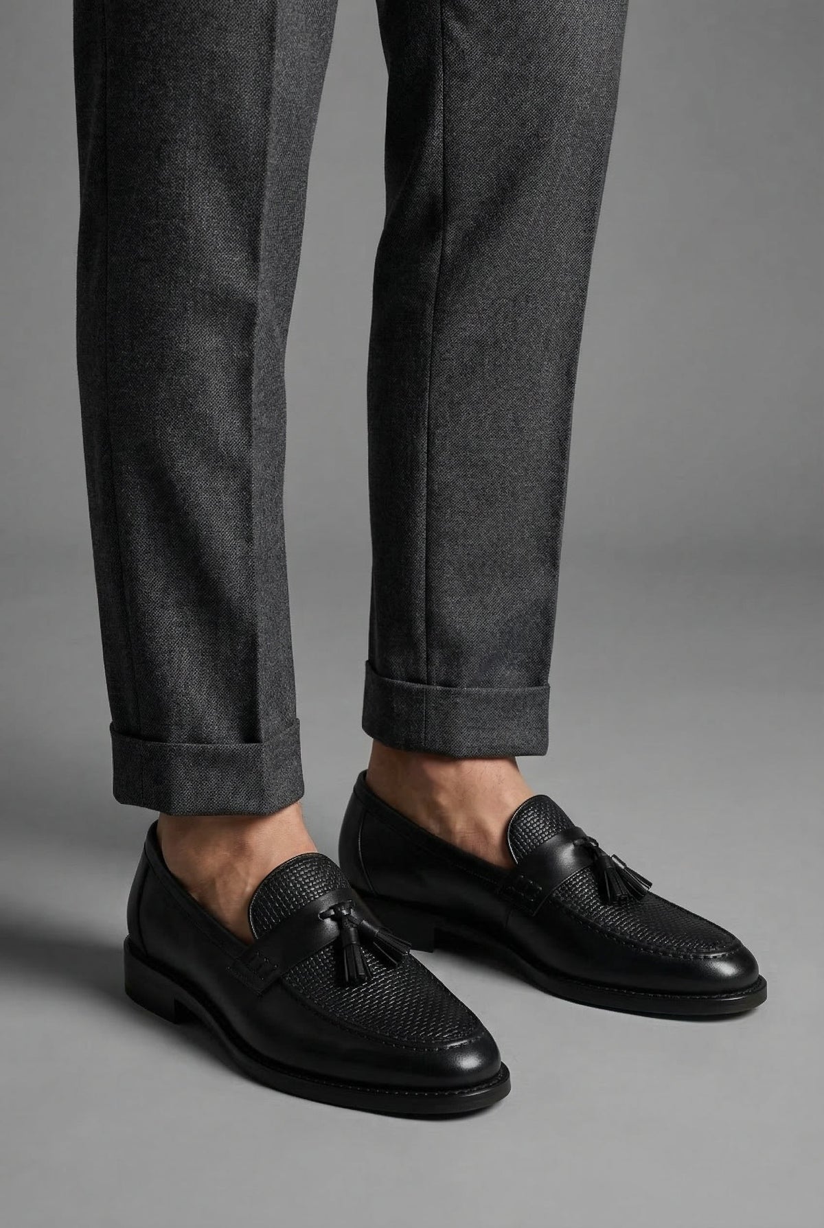 Mocassins à pampilles noirs portés avec un pantalon de flanelle gris