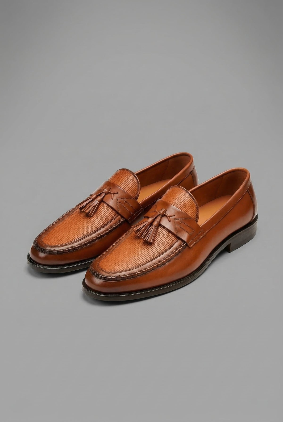 Paire de mocassins à pampilles marron, empeigne tressée, vue de trois quarts