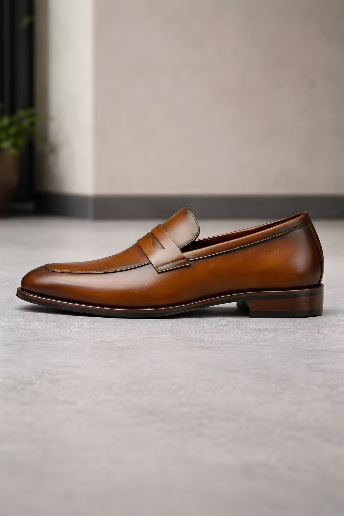 Mocassin penny marron posé sur un sol de pierre claire