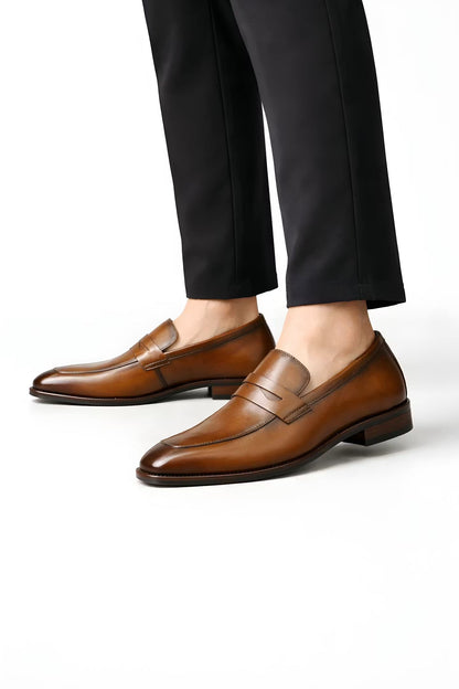 Mocassins penny marron portés avec un pantalon noir