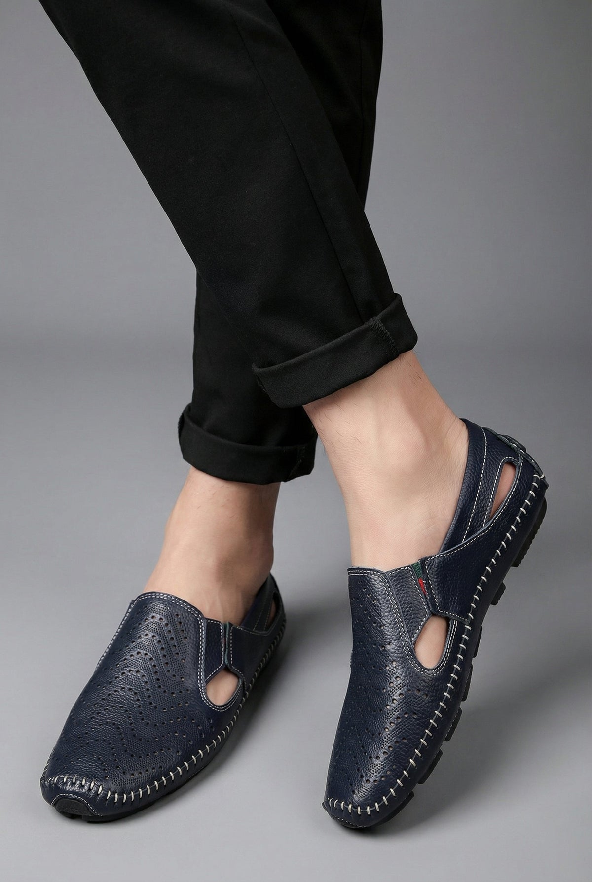Mocassins perforés bleu marine portés avec un pantalon retroussé
