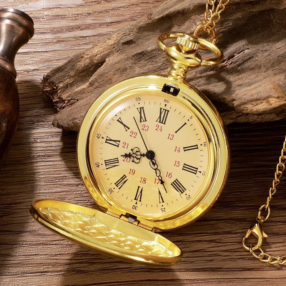 Montre de poche dorée ouverte, cadran crème à chiffres romains et rouges, posée sur du bois