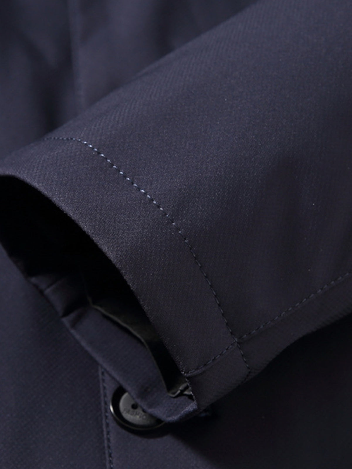 Manteau bleu marine, détail de la manche avec couture et bouton