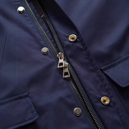 Gros plan sur la fermeture zippée et les boutons-pression d'une veste bleu marine