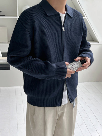 Veste en maille côtelée bleu marine, zip ouvert et col chemise, plan rapproché