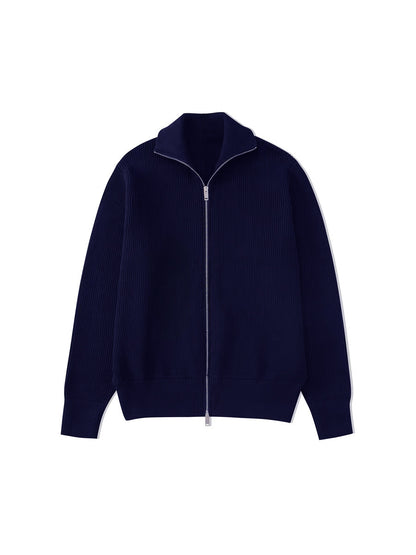 Cardigan bleu marine en maille côtelée, col ouvert et zip argenté, posé à plat sur fond blanc