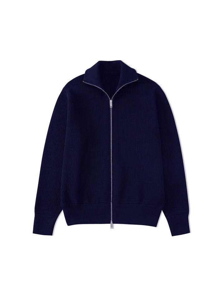 Cardigan bleu marine en maille côtelée, col ouvert et zip argenté, posé à plat sur fond blanc