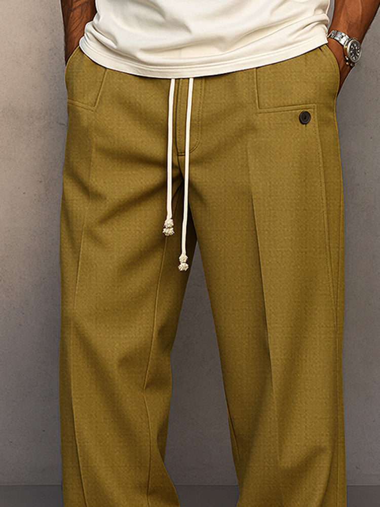Gros plan sur la taille du pantalon moutarde : cordon écru, poche et bouton foncé