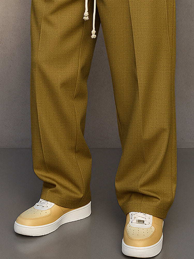 Bas du pantalon large moutarde tombant sur des baskets crème à semelle épaisse