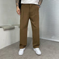 Pantalon large brun tabac à pinces, taille à passants et baskets blanches