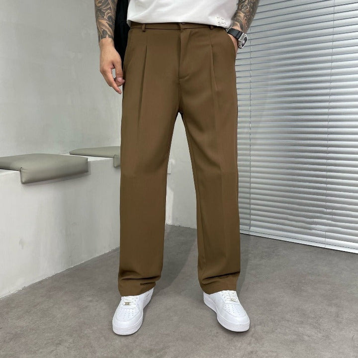 Pantalon large brun tabac à pinces, taille à passants et baskets blanches