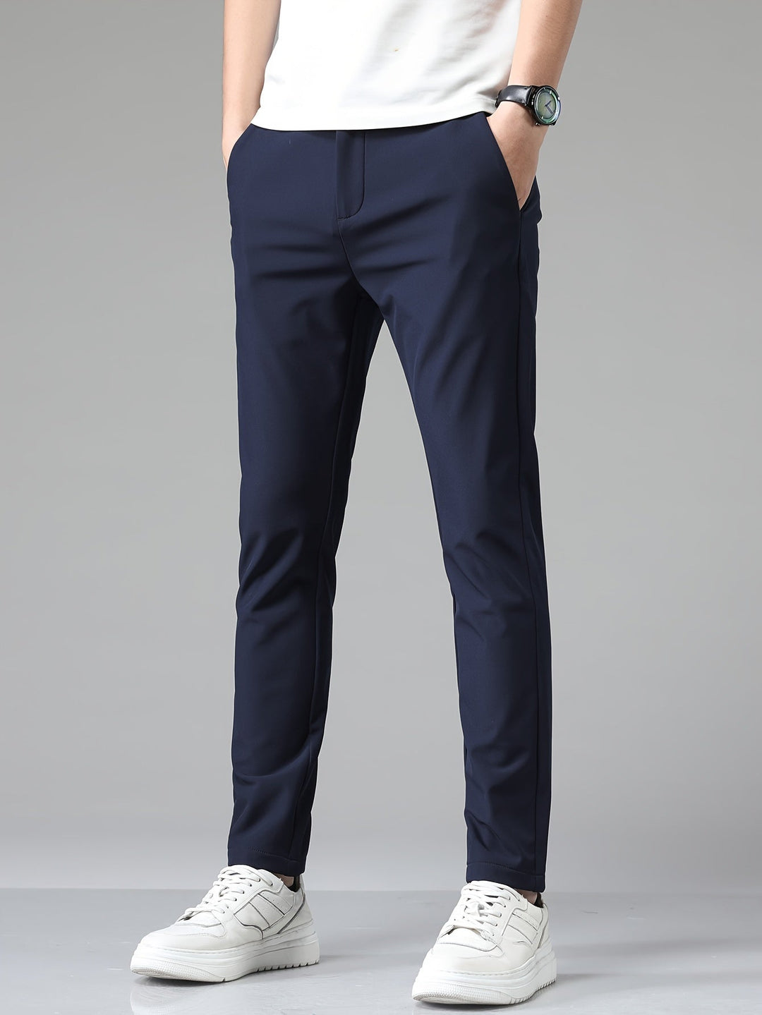 Pantalon ajusté bleu marine vu de face, poches latérales et baskets blanches