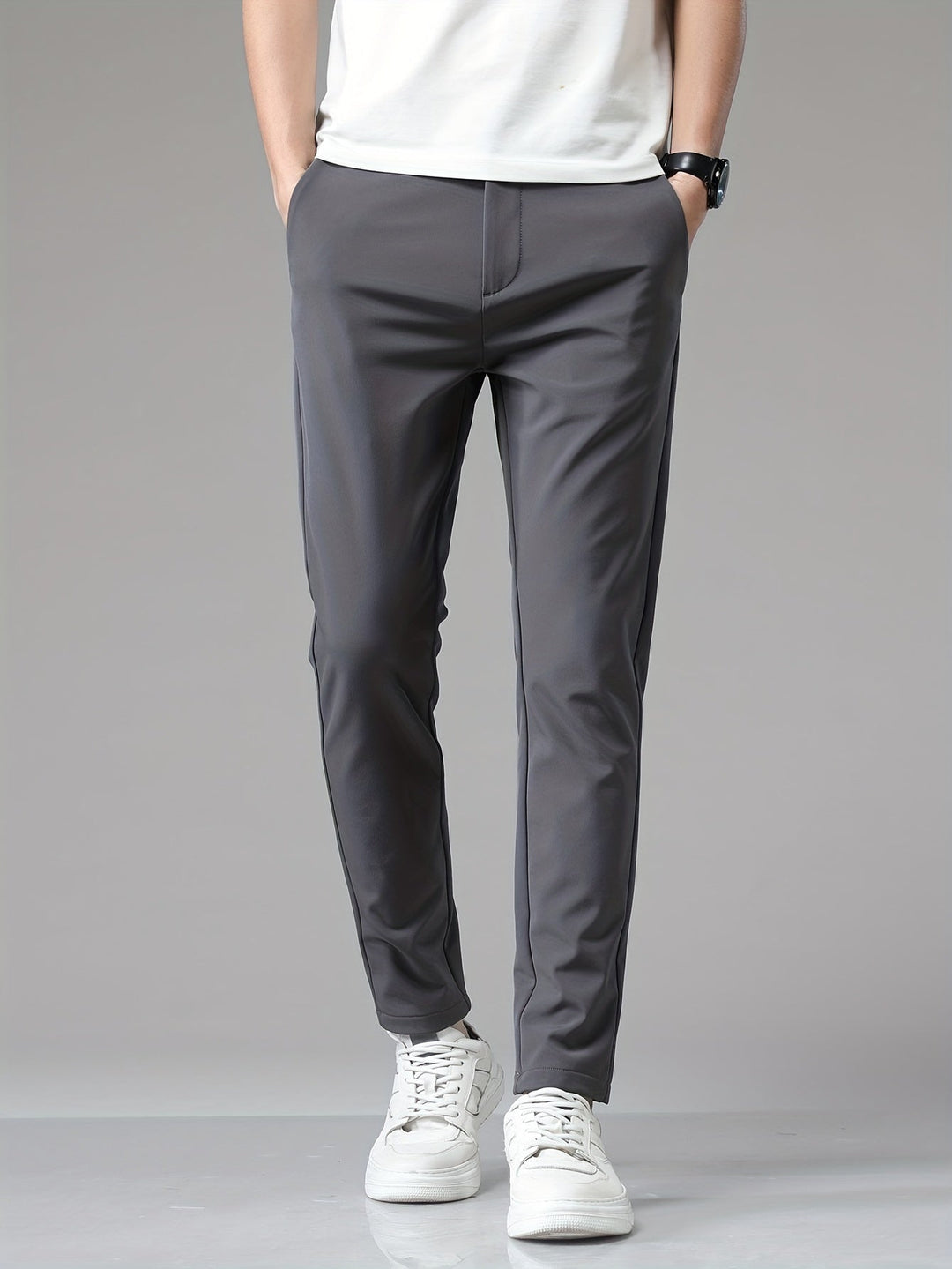Pantalon ajusté gris à jambe fuselée, mains dans les poches et t-shirt blanc