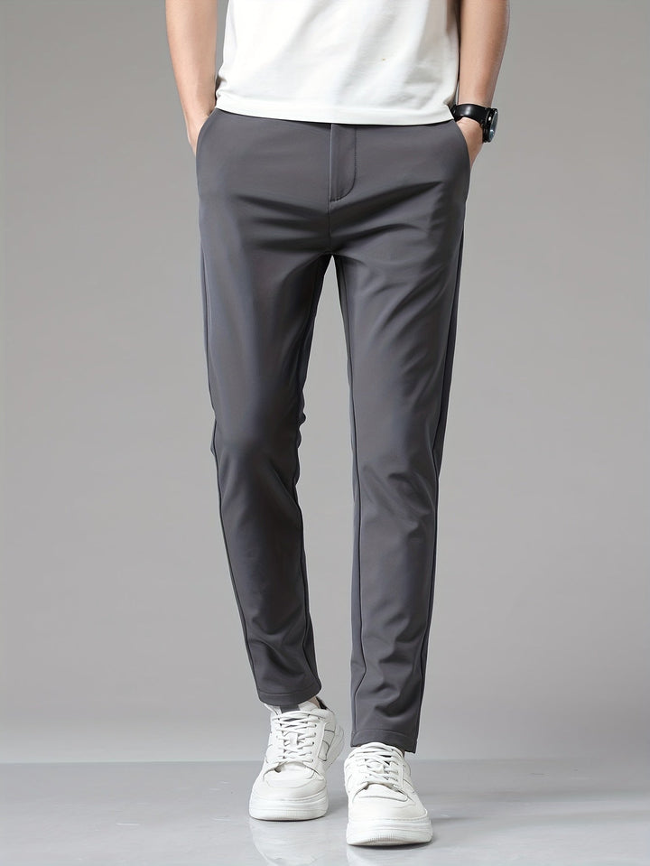 Pantalon ajusté gris à jambe fuselée, mains dans les poches et t-shirt blanc
