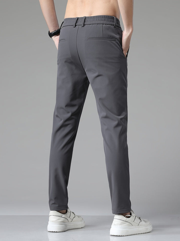 Dos du pantalon ajusté gris, taille élastique apparente et poches passepoilées