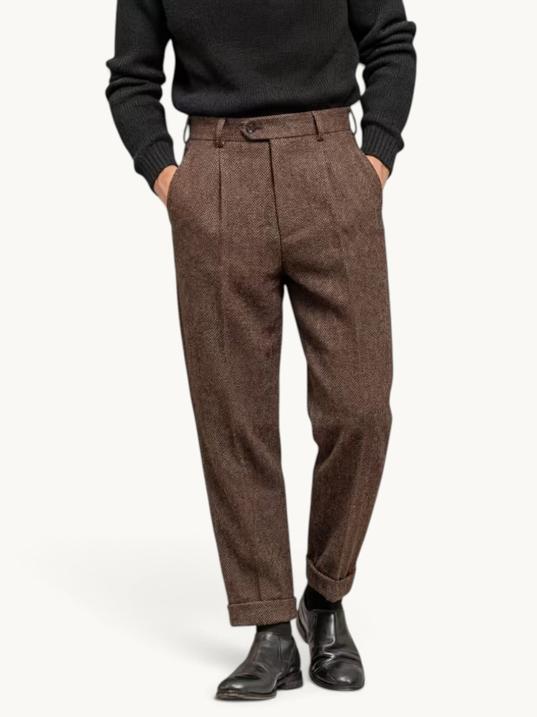 Pantalon habillé brun à plis en chevrons porté avec un pull noir et des bottines
