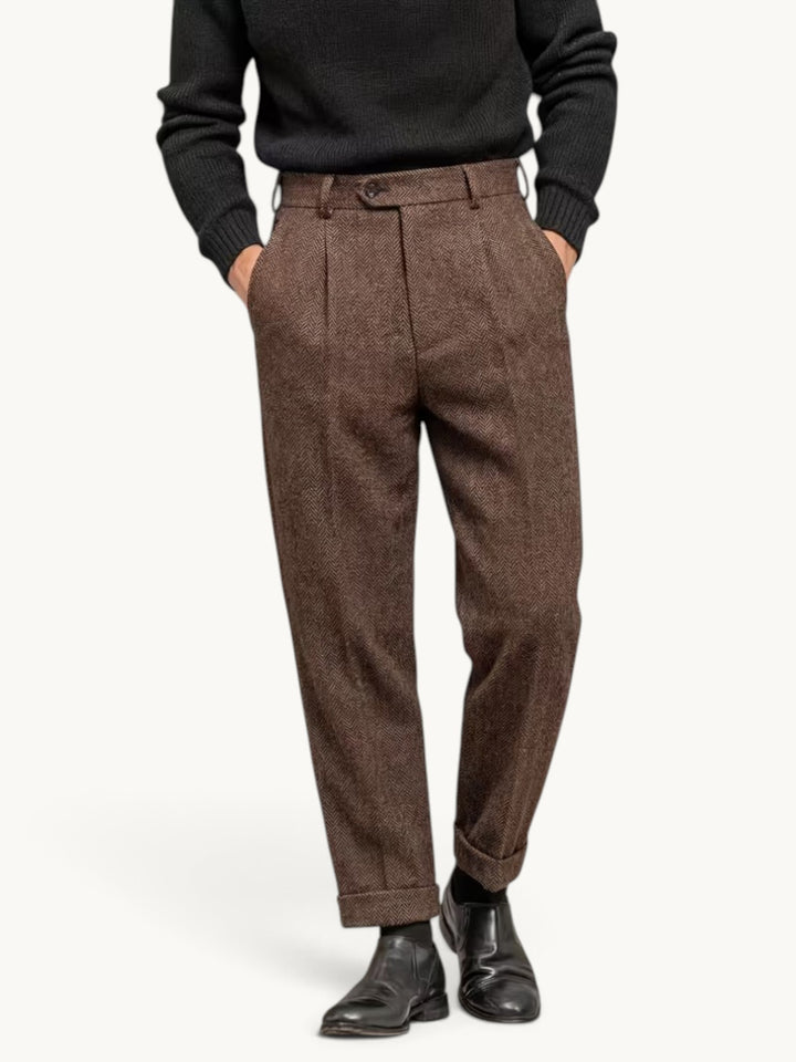 Pantalon habillé brun à plis en chevrons porté avec un pull noir et des bottines