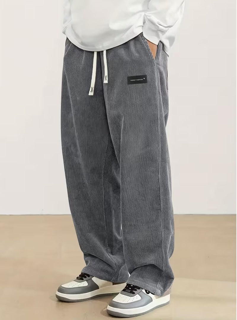 Pantalon large en velours côtelé gris, cordon écru et étiquette noire à la hanche