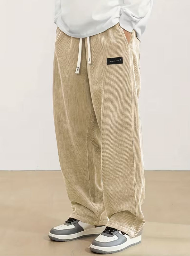 Pantalon large en velours côtelé beige, cordon écru et étiquette noire à la hanche