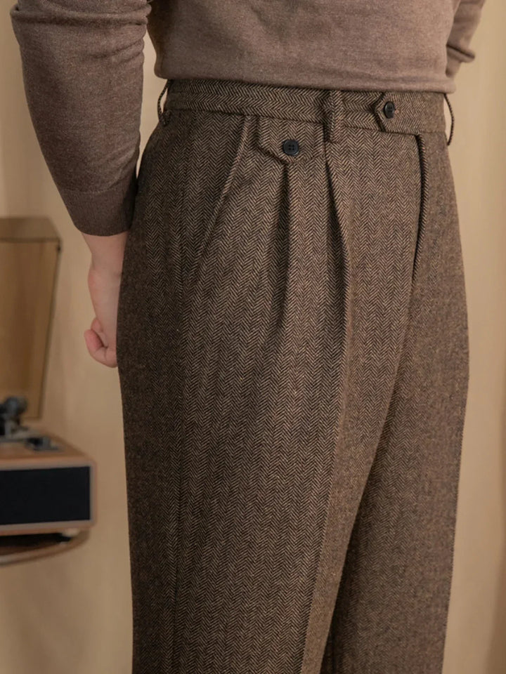 Pantalon à plis en chevrons brun porté avec un pull beige, vue de côté