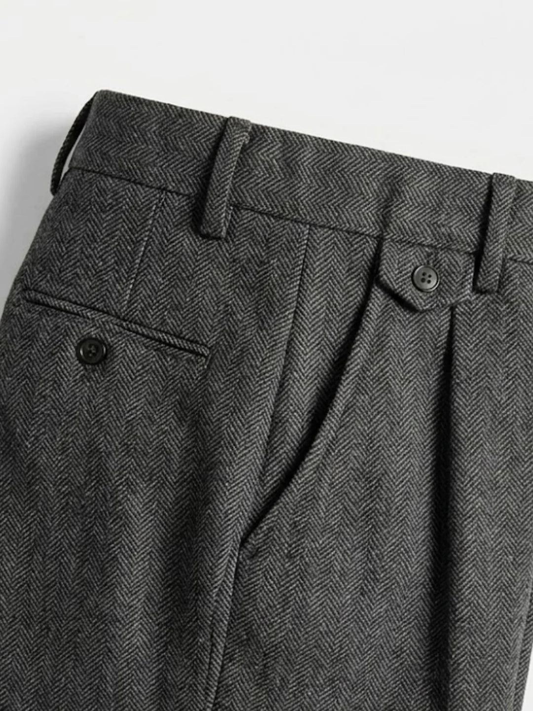 Gros plan sur la taille et la poche arrière du pantalon en chevrons gris