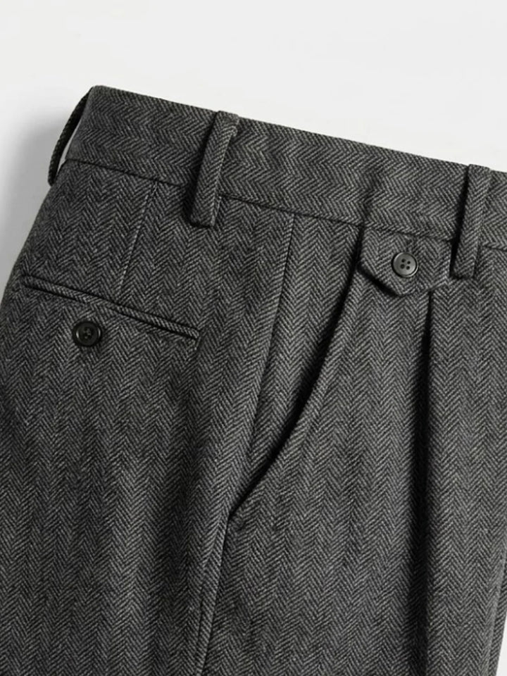 Gros plan sur la taille et la poche arrière du pantalon en chevrons gris