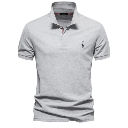 Polo en piqué gris clair chiné, col à liseré rayé et petite girafe brodée sur la poitrine