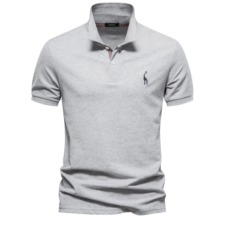 Polo en piqué gris clair chiné, col à liseré rayé et petite girafe brodée sur la poitrine