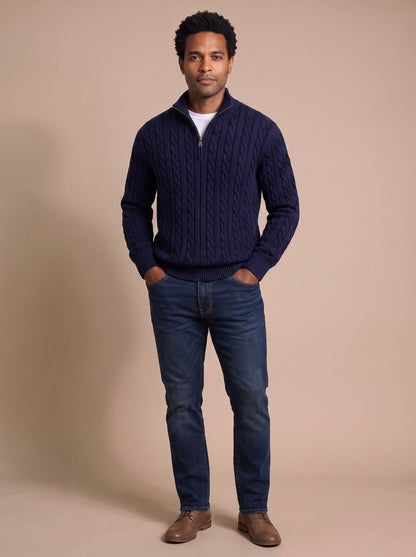 Pull camionneur torsadé bleu marine porté avec un jean