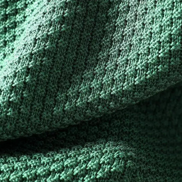 Détail de la maille texturée en relief d'un pull vert