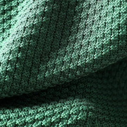 Détail de la maille texturée en relief d'un pull vert